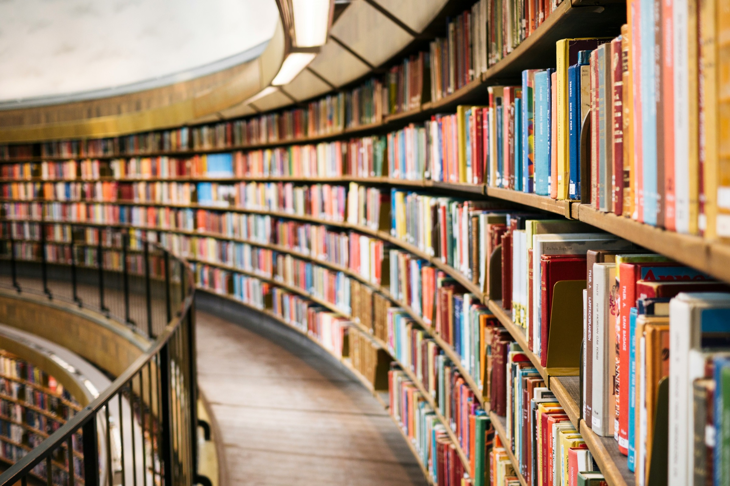 A curved wall of colourful library books